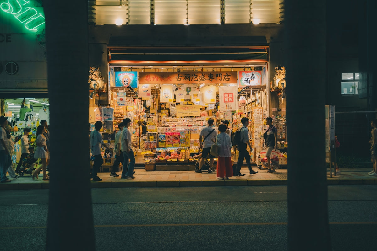 A group of people standing outside of a store at night